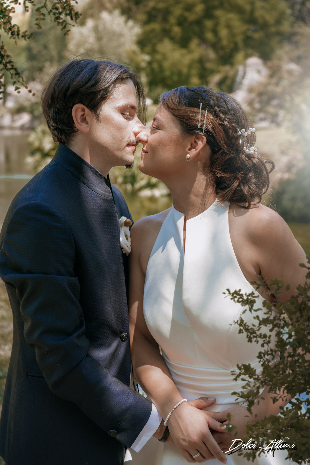 fotografo matrimonio giardino di ninfa, coppia di sposi tra i rami che si stanno per dare un bacio